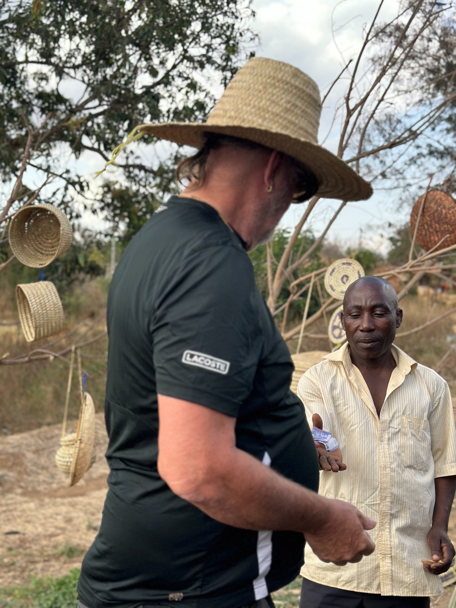 Kibwana's road-trip client paying a local roadside craft vendor in Tanzania
