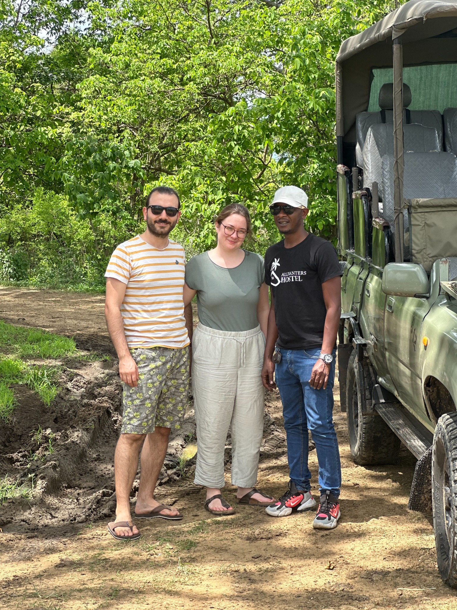 Kibwana with Gallivanters safari guests beside a safari vehicle in Tanzania