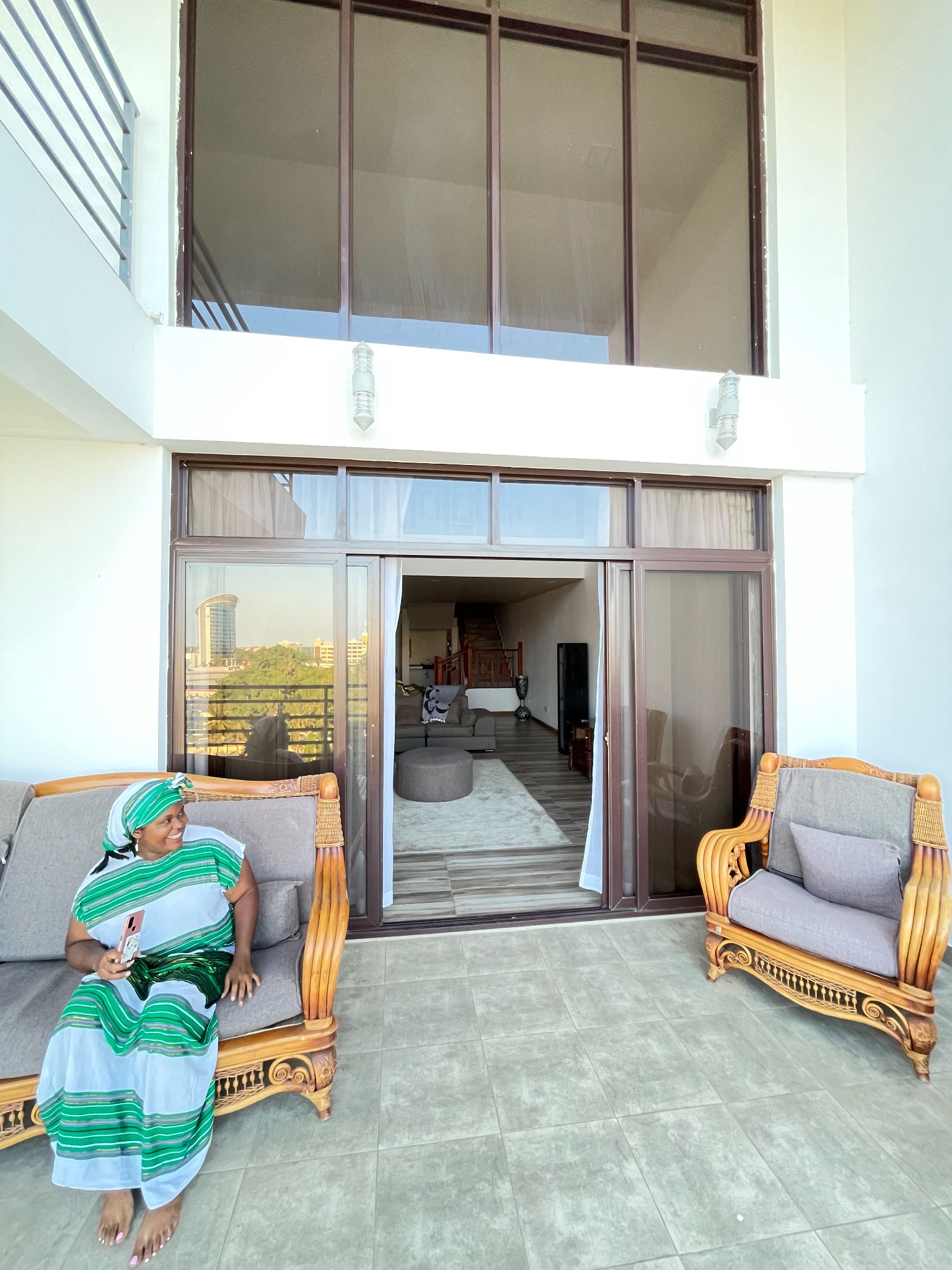 Tamara seated on the balcony of the eighth-floor Dar es Salaam duplex Airbnb