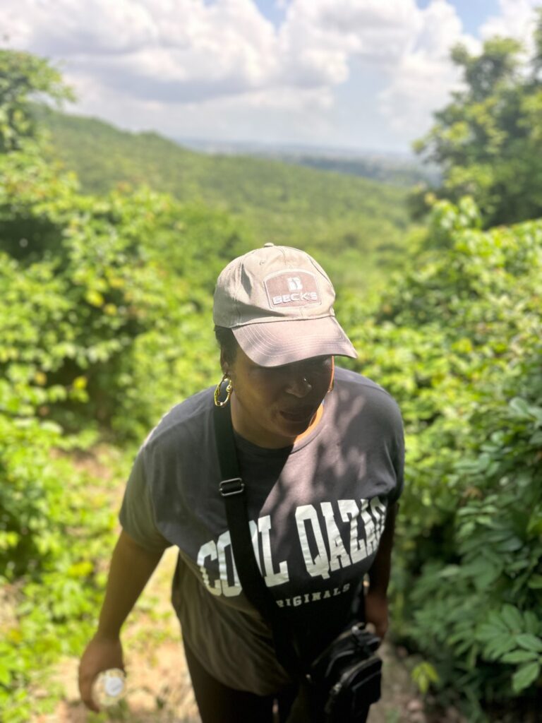 Tamara walking through green hills during a slow-travel experience in Tanzania