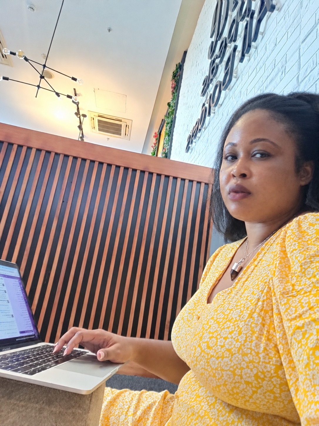 Tamara working on her MacBook at a cafe in Dar es Salaam