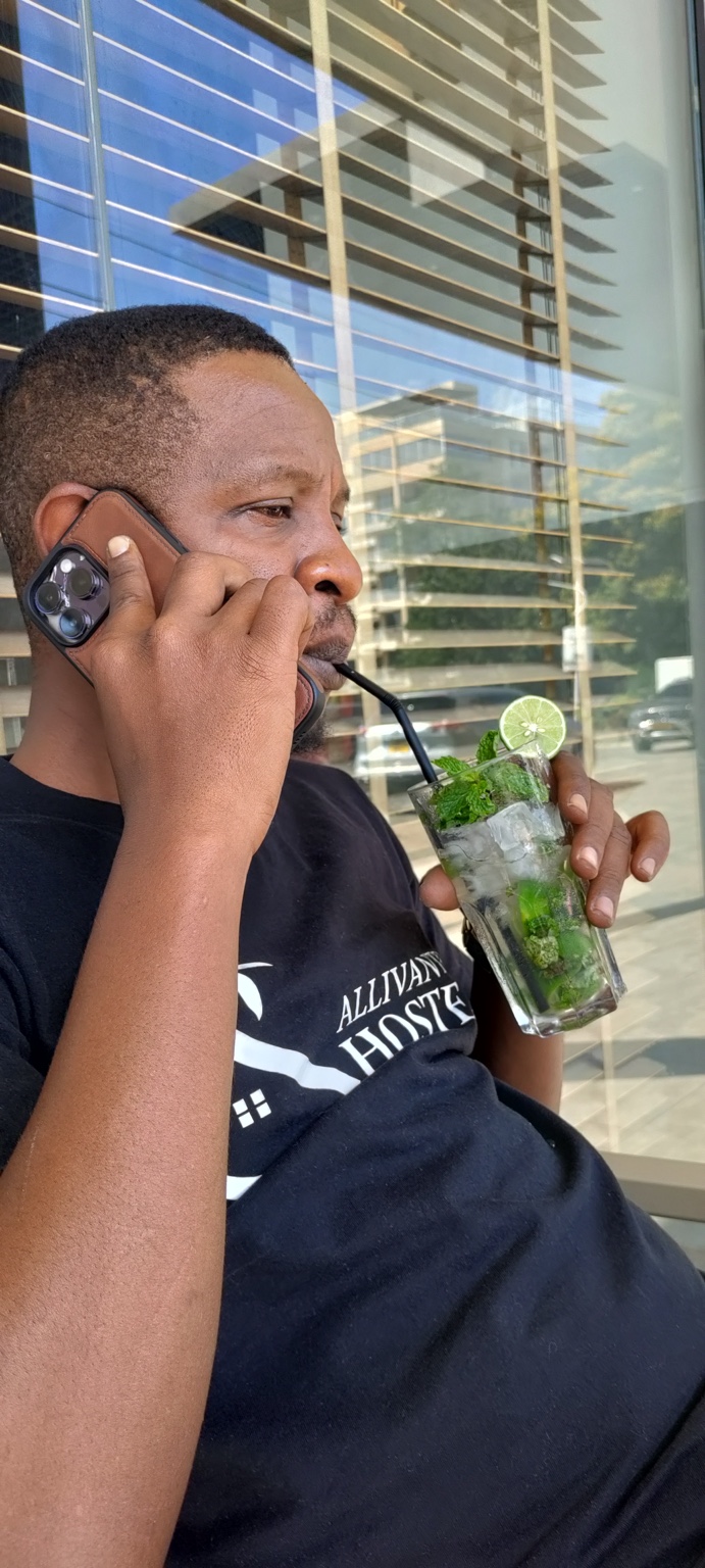 Kibwana wearing a Gallivanters Hostel shirt and speaking on the phone during the move.