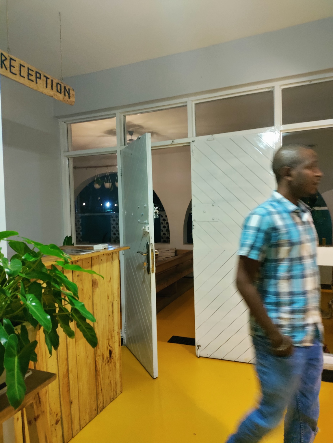 Kibwana beside the wooden reception desk at the former Gallivanters Hostel.